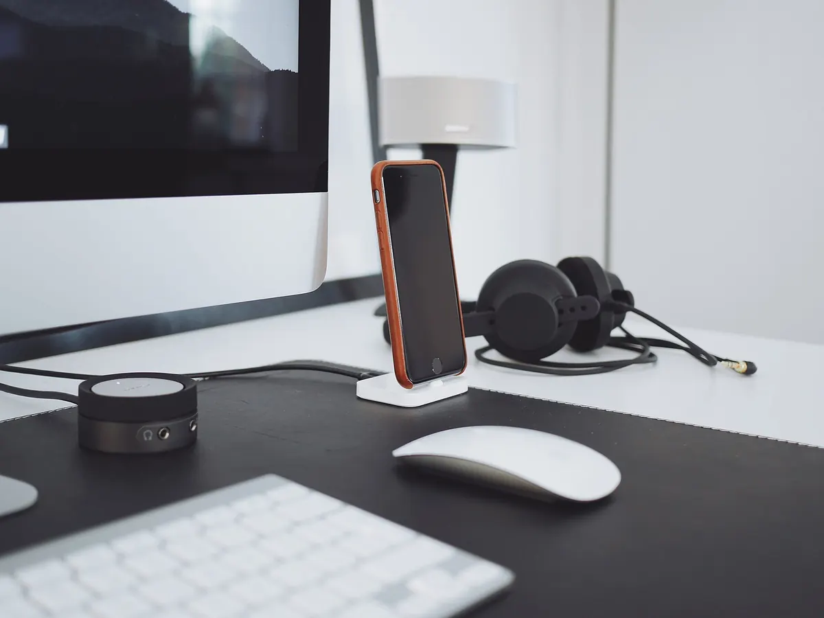 Escritorio con auriculares, teclado y un móvil